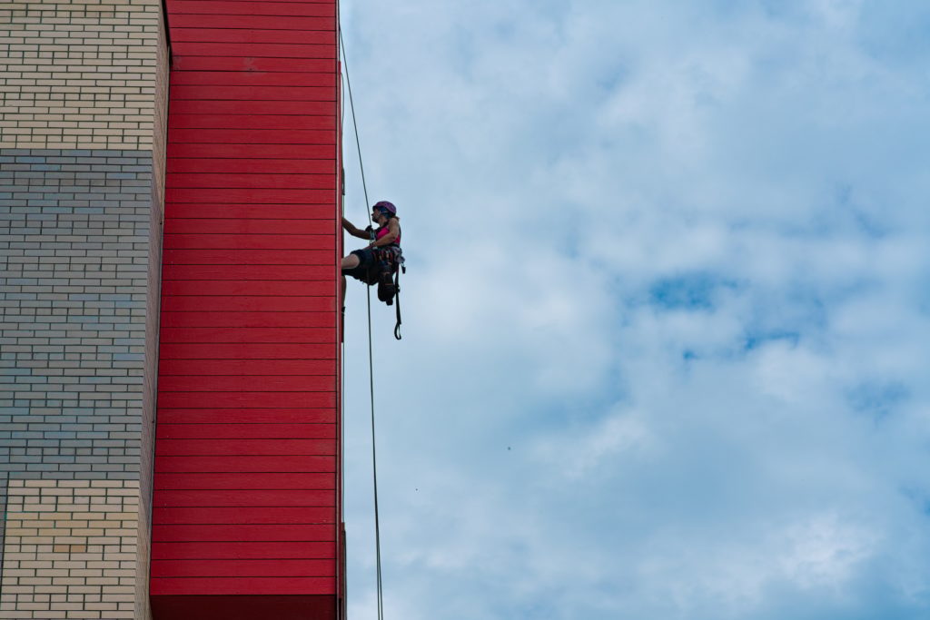 Industrial climber washes the Windows of the facade of a modern building. Small business concept